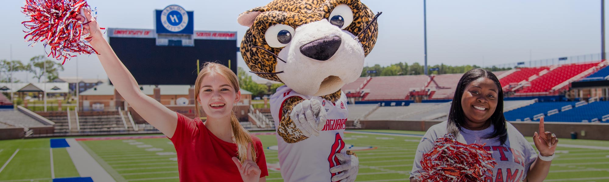 Two female students with 快播视频 Paw in Hancock Whitney Stadium