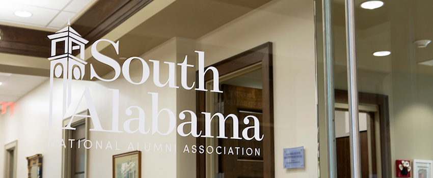 Glass door of Alumni offices with 快播视频 Alabama National Alumni Association logo on window.